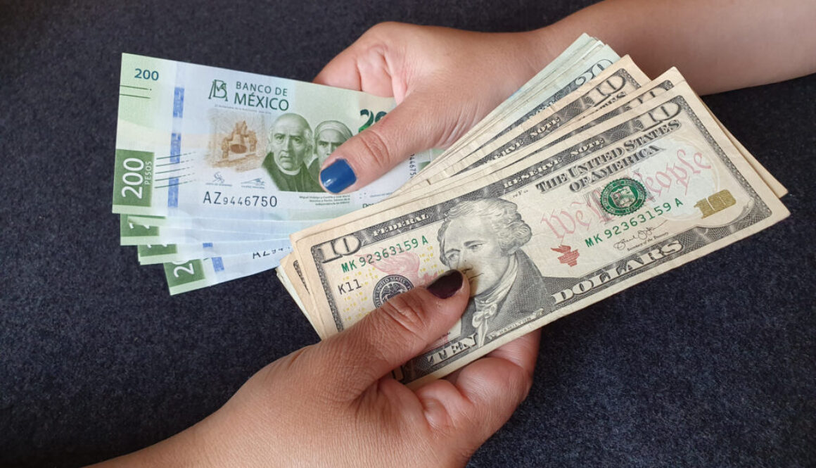 women hands exchanging Mexican banknotes and American dollar money