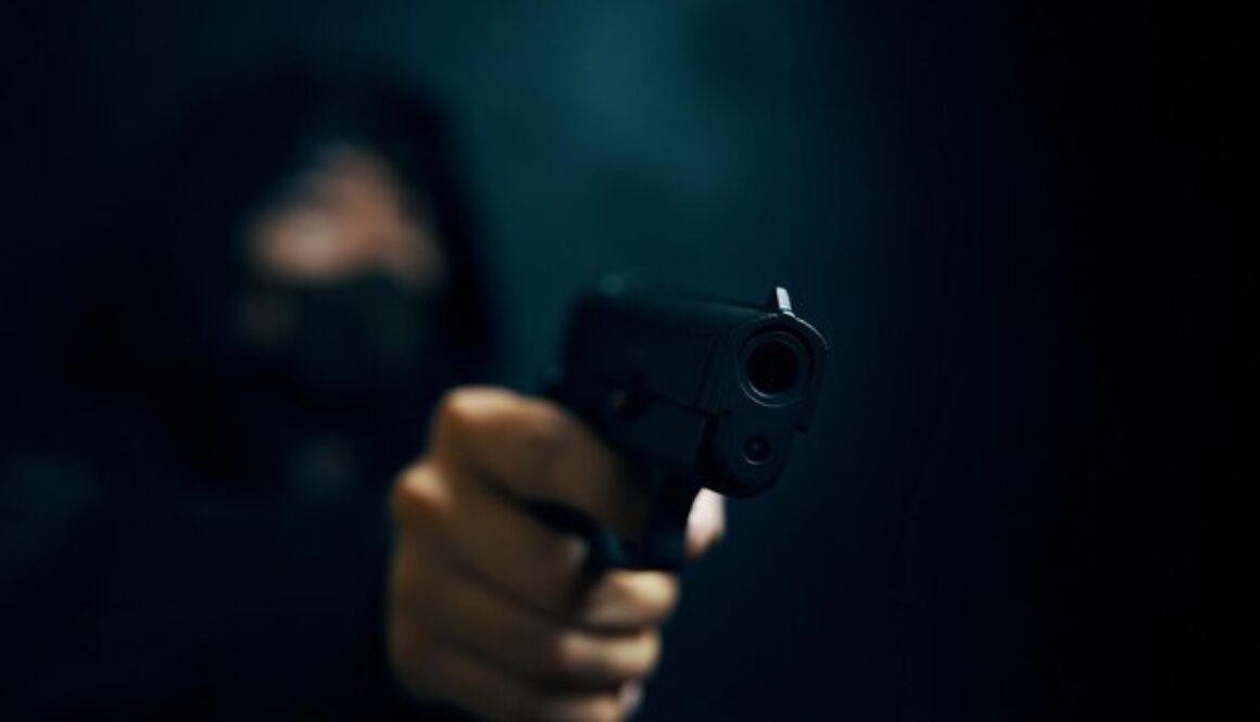 hombre-capucha-amenaza-arma-fuego-ladron-enmascarado-arma-fuego-manos-personas-asesino-o-armado_72464-2104